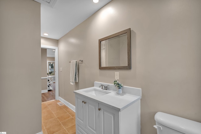 bathroom featuring visible vents, baseboards, toilet, tile patterned floors, and vanity