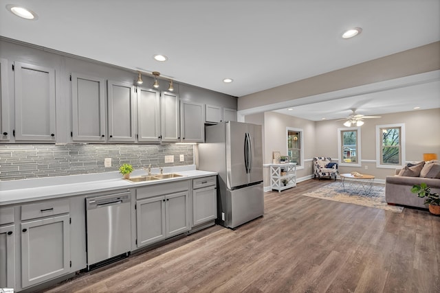 kitchen featuring a sink, gray cabinetry, stainless steel appliances, tasteful backsplash, and open floor plan