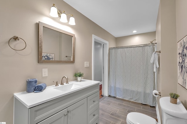 full bath featuring vanity and toilet