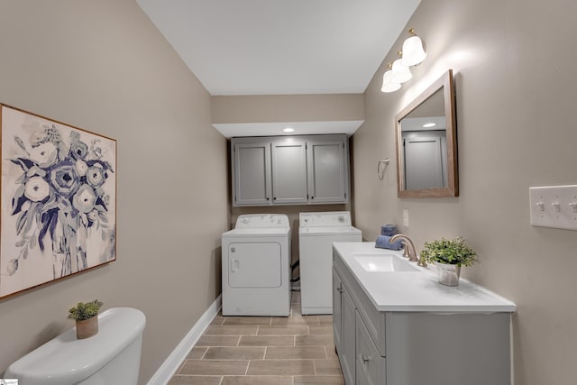 bathroom with wood finish floors, baseboards, washer and clothes dryer, toilet, and vanity