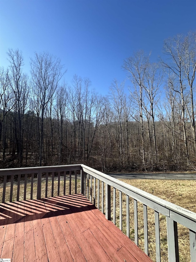 wooden deck featuring a forest view