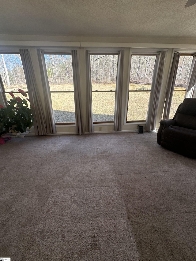 unfurnished living room featuring visible vents, a textured ceiling, and carpet