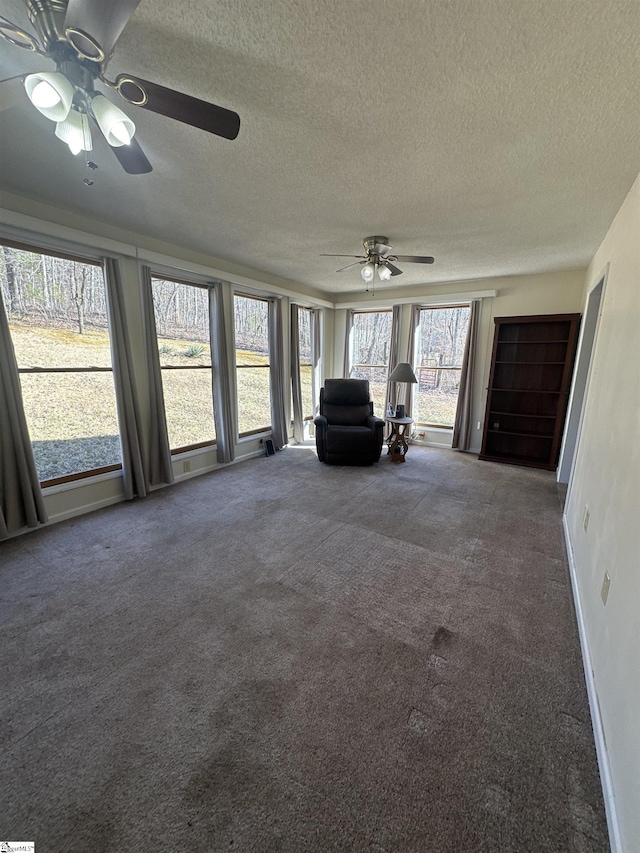 unfurnished sunroom with a ceiling fan