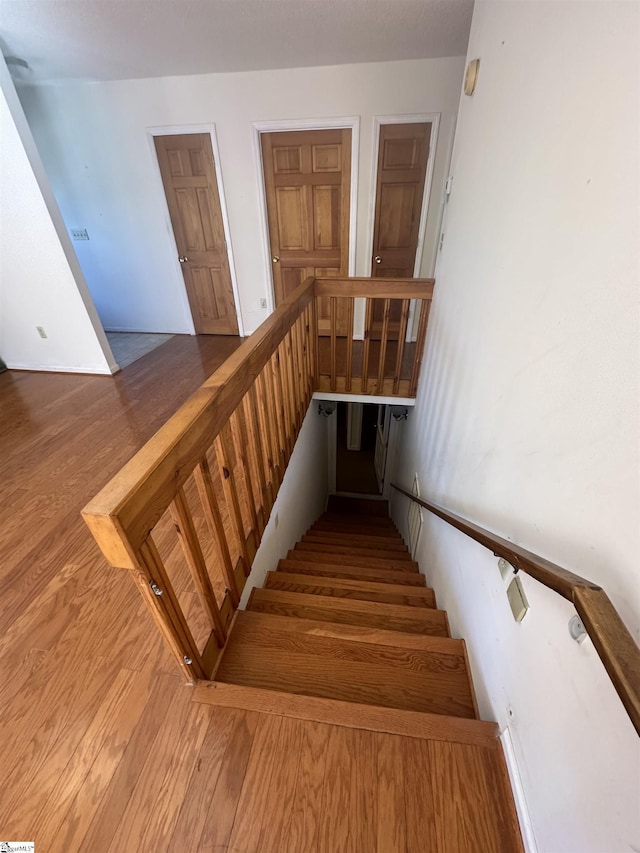 stairs featuring wood finished floors