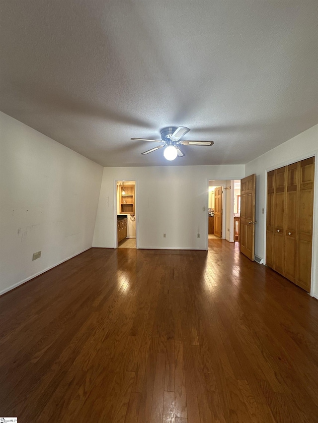 interior space featuring a textured ceiling, a ceiling fan, and wood finished floors