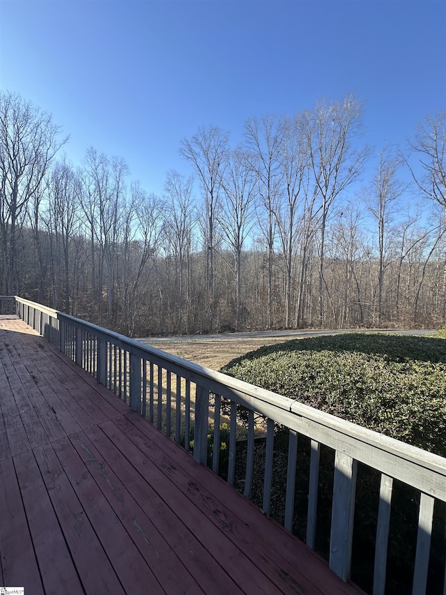 wooden terrace with a wooded view