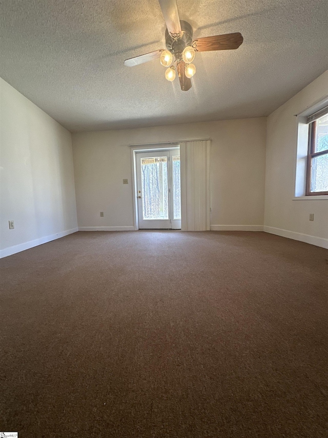 empty room with a ceiling fan, carpet, baseboards, and a textured ceiling