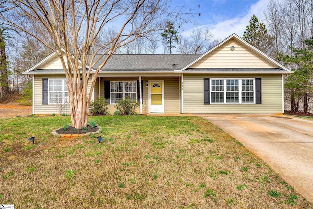 ranch-style house with concrete driveway and a front lawn