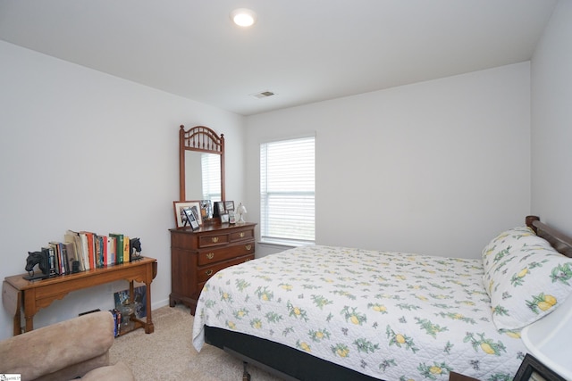 bedroom featuring visible vents and light colored carpet