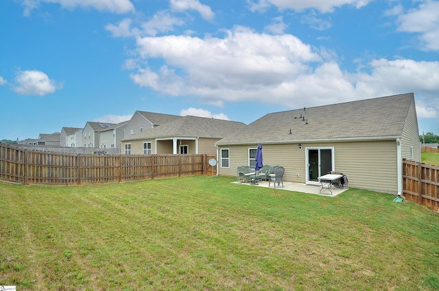 rear view of property with a yard, a patio area, and a fenced backyard