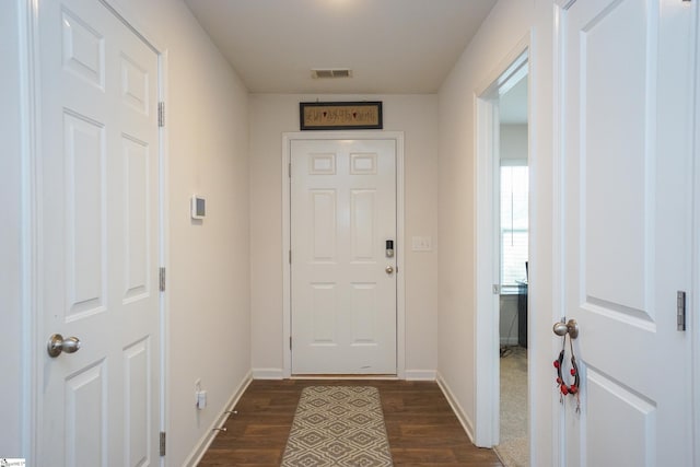 doorway to outside with visible vents, baseboards, and dark wood-type flooring