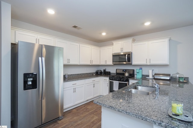 kitchen featuring a sink, appliances with stainless steel finishes, white cabinets, and dark wood finished floors