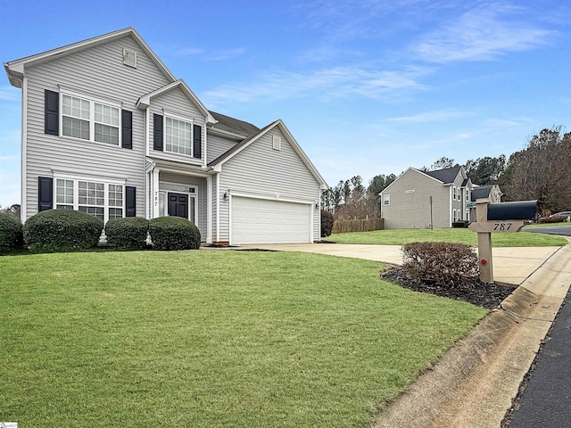 traditional-style home featuring a garage, driveway, and a front yard