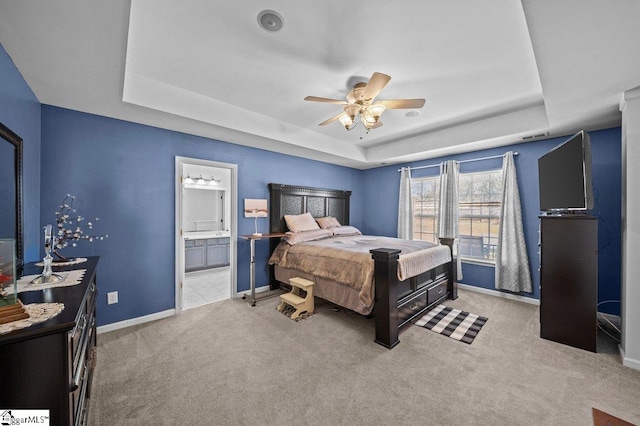 bedroom featuring a raised ceiling, baseboards, and carpet floors