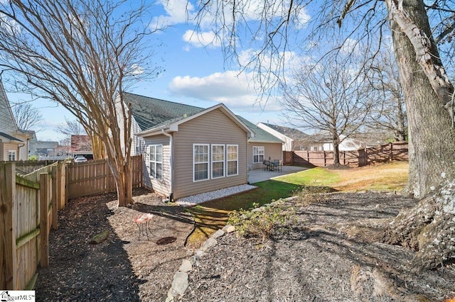 back of property with a fenced backyard and a patio area