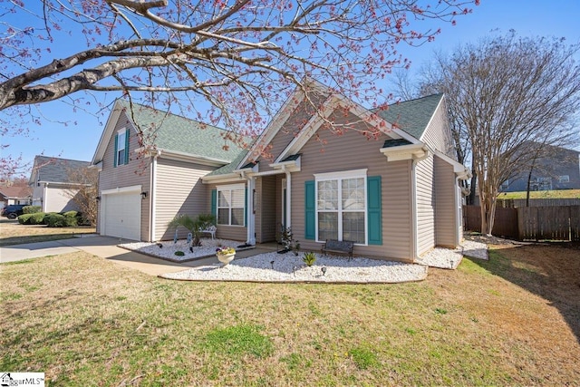 view of front of property featuring concrete driveway, an attached garage, fence, and a front yard