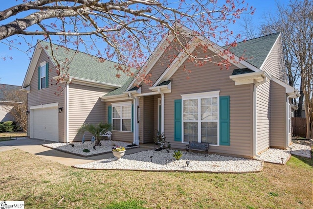 view of front of house with a front yard, concrete driveway, a garage, and roof with shingles