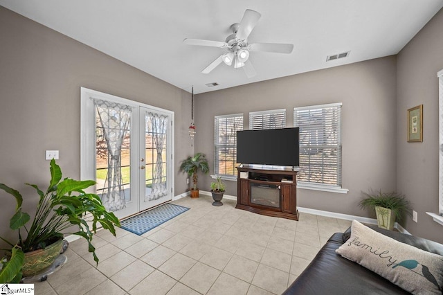 living area featuring visible vents, a ceiling fan, french doors, light tile patterned flooring, and baseboards