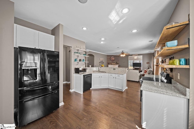 kitchen with open shelves, a peninsula, arched walkways, black appliances, and a sink