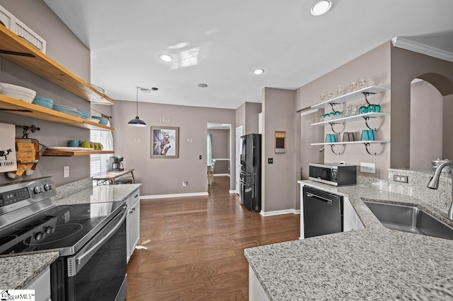 kitchen with open shelves, a sink, arched walkways, appliances with stainless steel finishes, and dark wood-style flooring