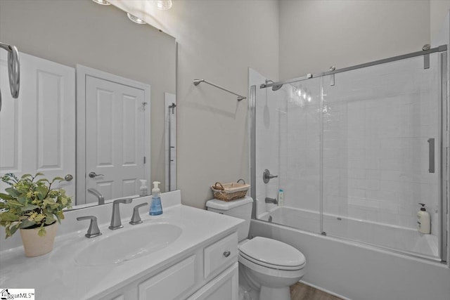 full bathroom with enclosed tub / shower combo, toilet, and vanity