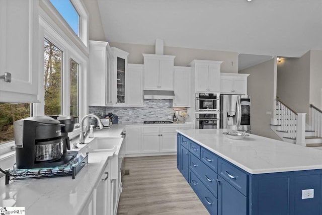 145 Brady Dr, Anderson, SC 29626 - kitchen featuring under cabinet range hood, white cabinets, stainless steel appliances, blue cabinets, and a sink