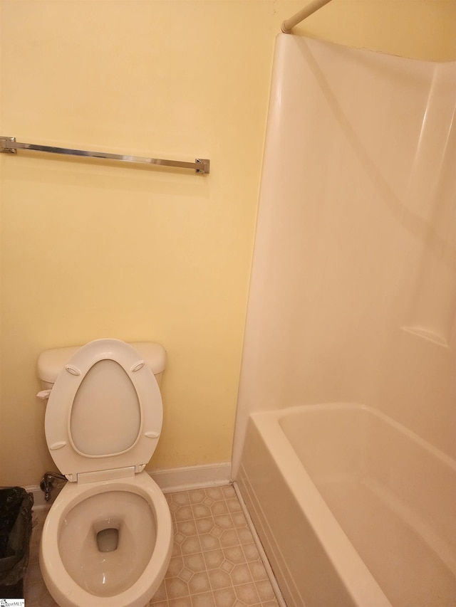 bathroom featuring tile patterned flooring, toilet, and baseboards