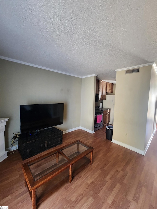 living room featuring baseboards, visible vents, dark wood-style flooring, a textured ceiling, and crown molding