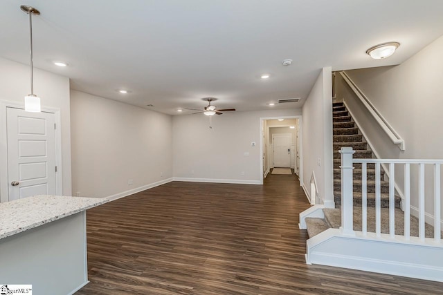 unfurnished living room with dark wood finished floors, stairs, recessed lighting, and baseboards