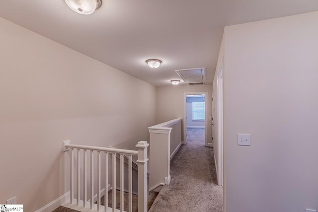 hallway featuring an upstairs landing, carpet flooring, attic access, and baseboards