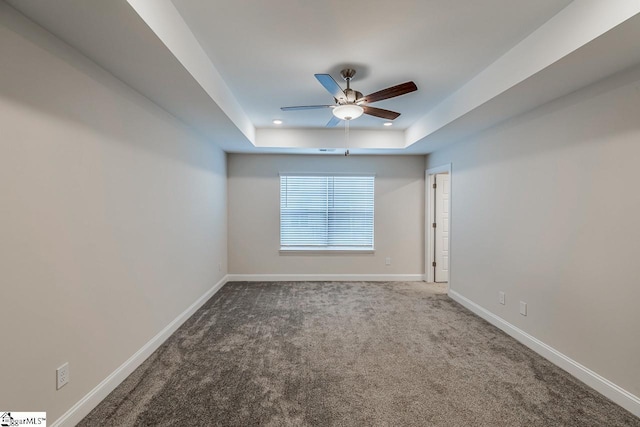 empty room with baseboards, carpet flooring, recessed lighting, a raised ceiling, and a ceiling fan