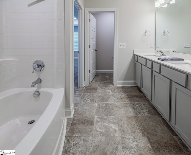 full bathroom with double vanity, shower / tub combination, baseboards, and a sink