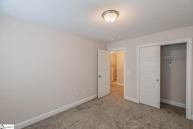 unfurnished bedroom featuring a closet, baseboards, and carpet floors