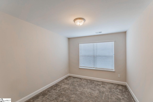 unfurnished room with visible vents, baseboards, and carpet floors