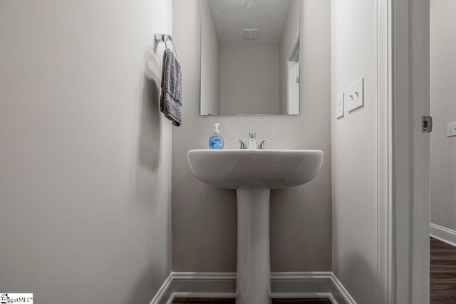 bathroom with wood finished floors and baseboards