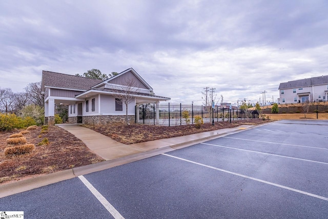 surrounding community featuring uncovered parking and fence