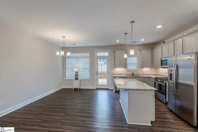 kitchen with a sink, appliances with stainless steel finishes, dark wood-style floors, and gray cabinetry