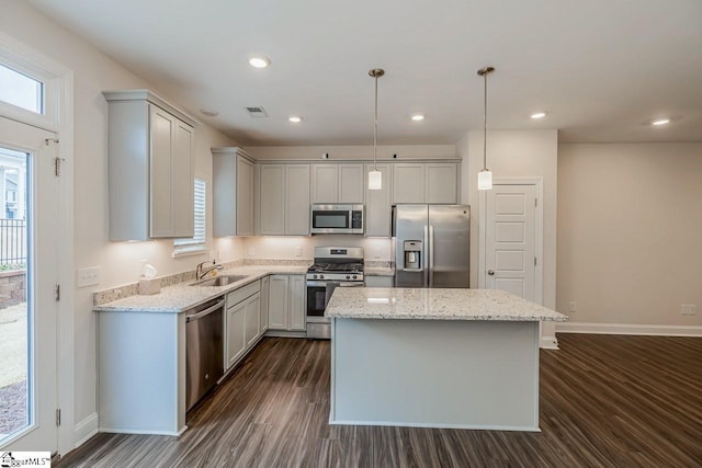 kitchen with a kitchen island, recessed lighting, appliances with stainless steel finishes, dark wood-style floors, and a sink