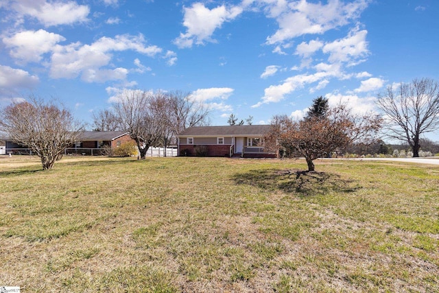 single story home with a front lawn and fence