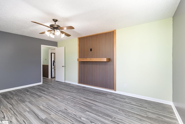 spare room featuring baseboards, a textured ceiling, a ceiling fan, and wood finished floors