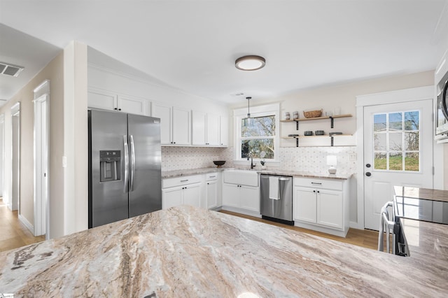 kitchen with visible vents, light stone countertops, backsplash, and appliances with stainless steel finishes