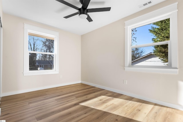 empty room with ceiling fan, light wood-style floors, visible vents, and baseboards