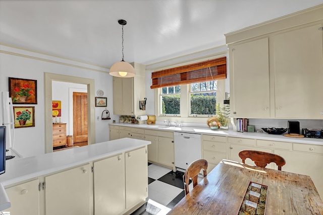 kitchen with a sink, pendant lighting, white dishwasher, and light countertops