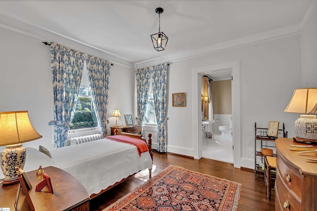 bedroom with radiator heating unit, ensuite bathroom, crown molding, and wood finished floors