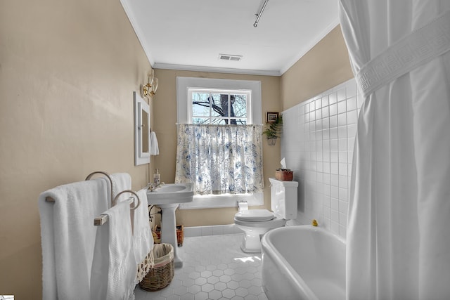 bathroom featuring visible vents, a bathtub, ornamental molding, and tile patterned flooring