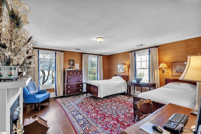 bedroom featuring visible vents, multiple windows, wood-type flooring, and crown molding