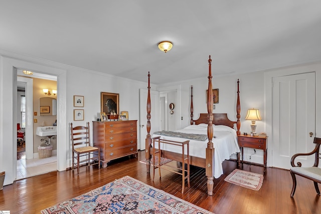 bedroom featuring a sink, hardwood / wood-style flooring, and ornamental molding