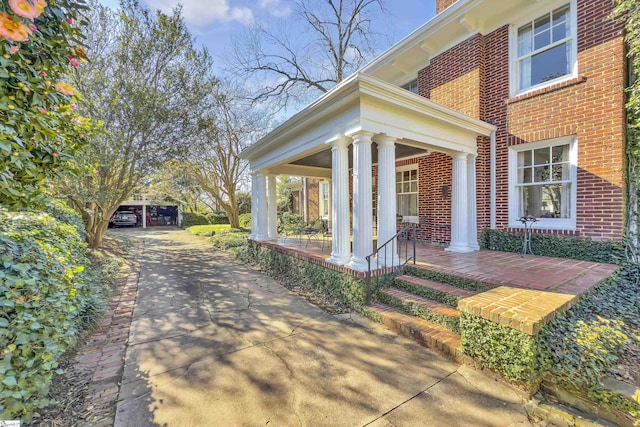 exterior space featuring a porch, brick siding, and a chimney