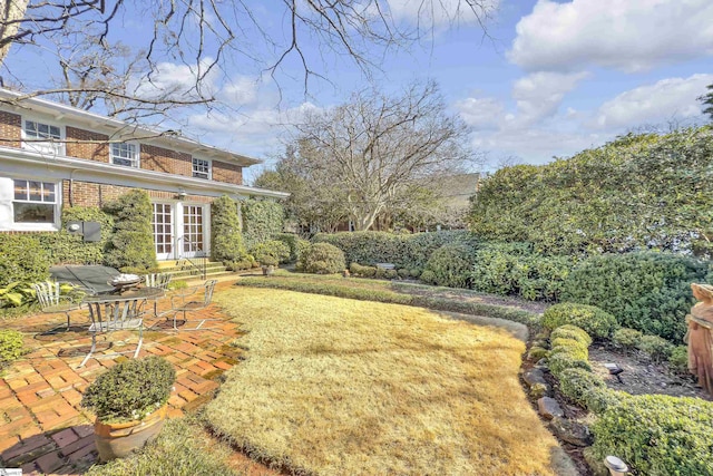 view of yard featuring french doors and a patio