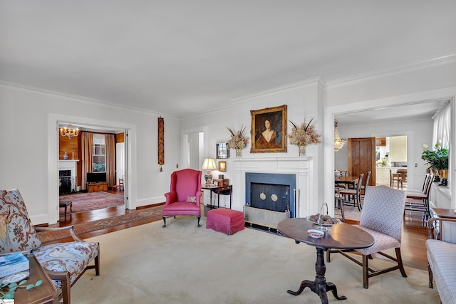 living area with wood finished floors, a fireplace, and ornamental molding